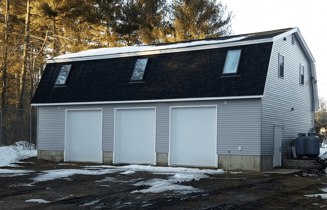 Three car detached garage with a gambrel roof and skylights in the loft, finished in winter